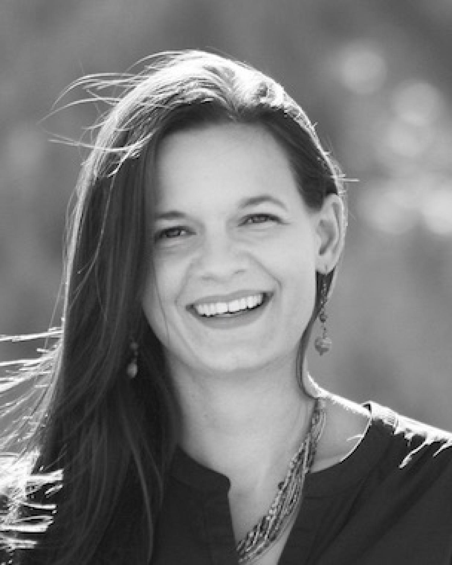 Black and white profile of a white woman with long dark hair, smiling.