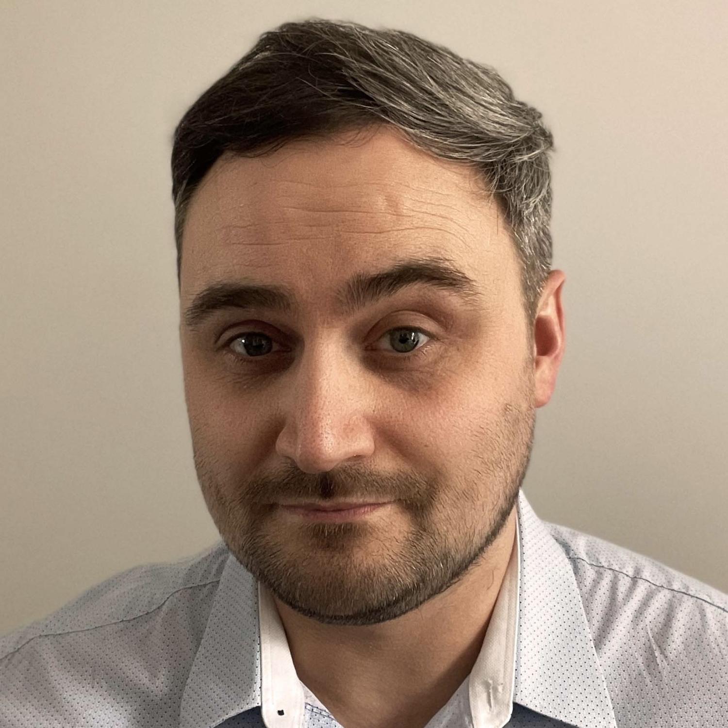 Profile of a middle-aged white man with dark brown hair and beard.