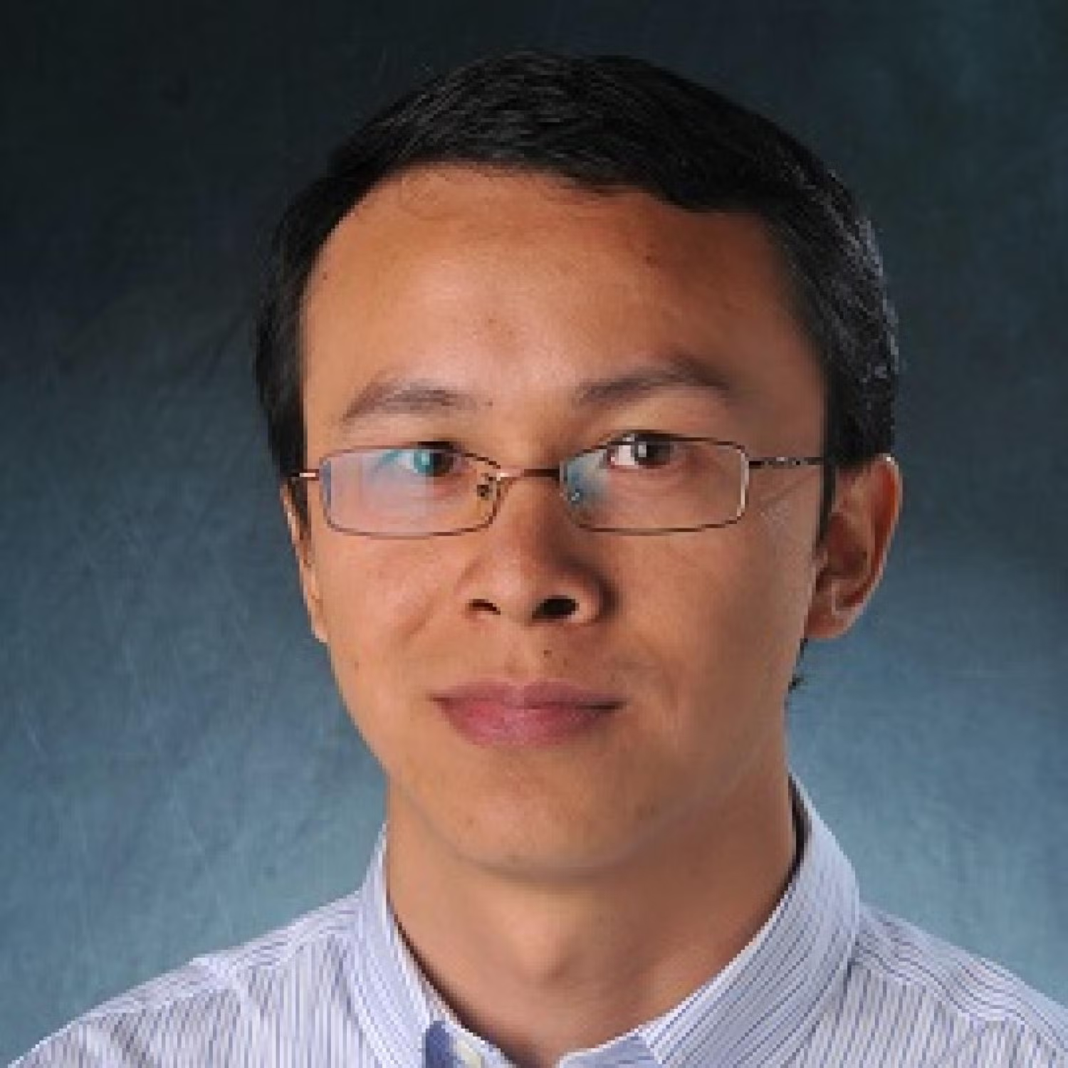 Profile of a young asian man with short black hair, wearing glasses.