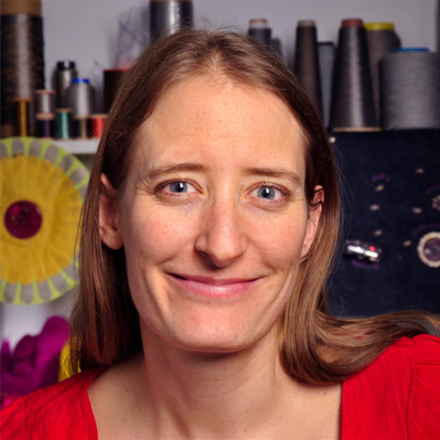 Profile of a white woman with long brown hair, smiling.