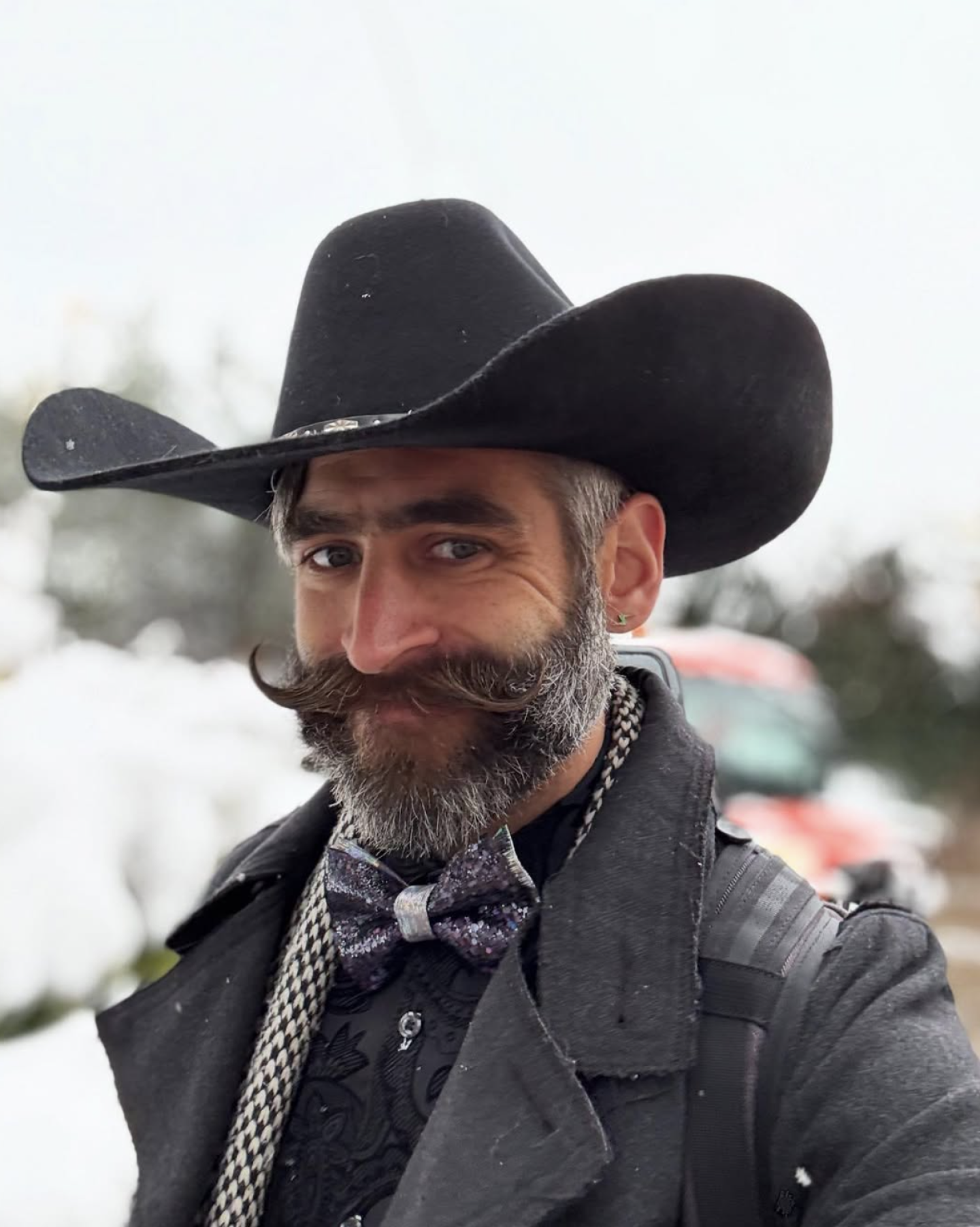 Profile image of a man with a curled mustache and beard, wearing a black cowboy hat.