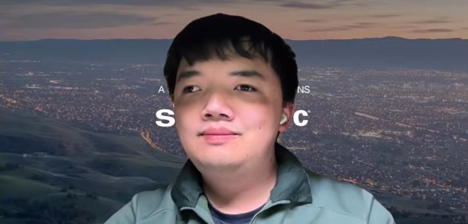 Profile of a young asian man with short black hair, smiling.