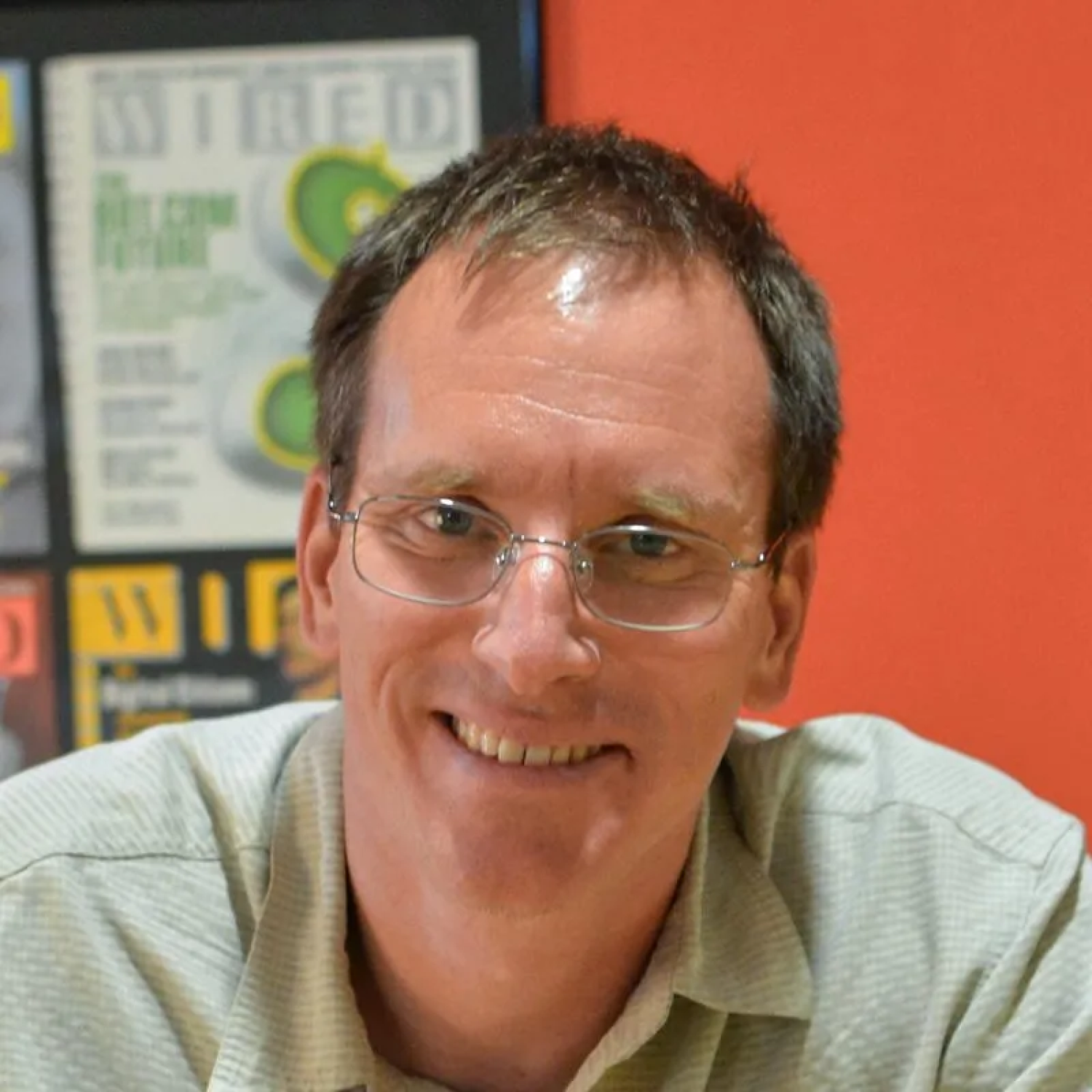 Profile of a middle aged white man with short brown hair and glasses, smiling.