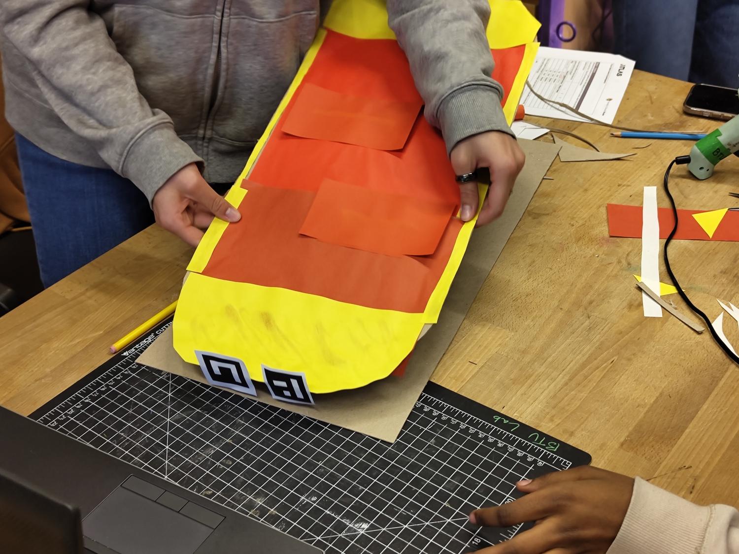 Person holding a skateboard shaped cardboard controller