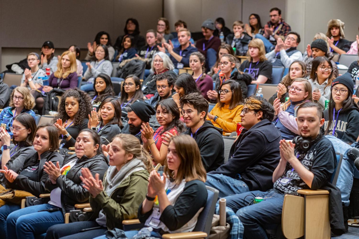 A large group of T9Hacks participants sit in Cofrin auditorium
