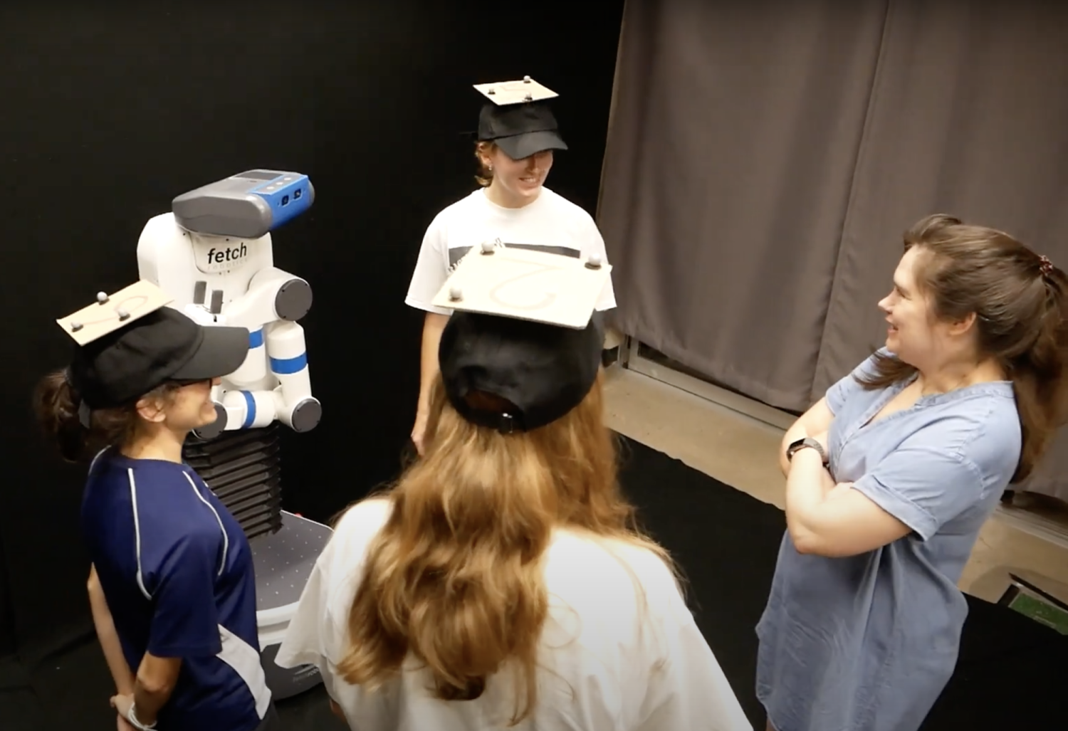 Robot turns to person entering the conversational group, even though she is not wearing a detectable hat like the other three members of the group.