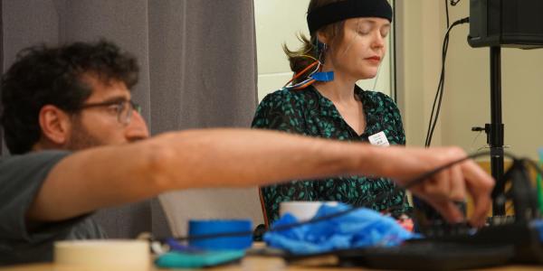 grace leslie on right wearing eeg headband prepares for brain music performance