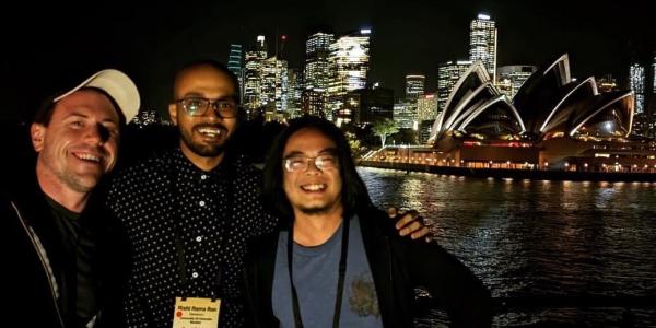 Hopkins, Vanukuru and Weng standing beside Sydney Harbor