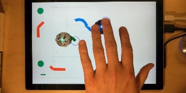 Demonstration of haptic video with small circular robots following a path created on screen by user.