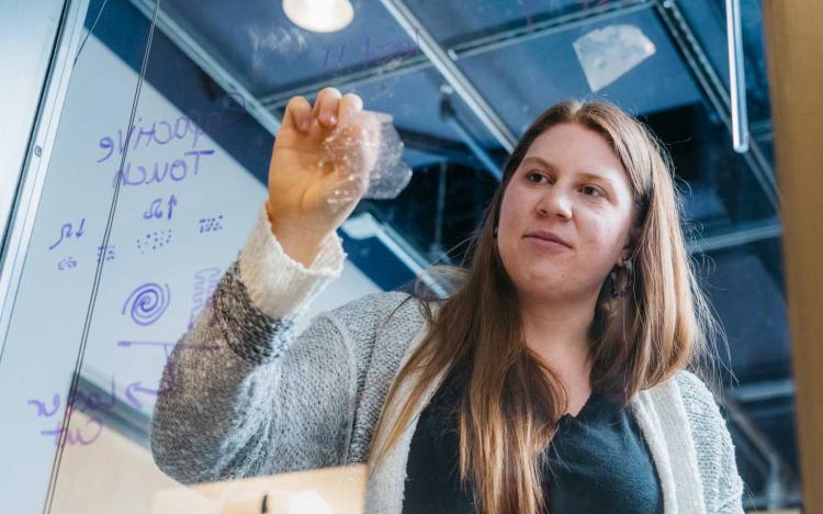 Fiona Bell peels bioplastic from window.