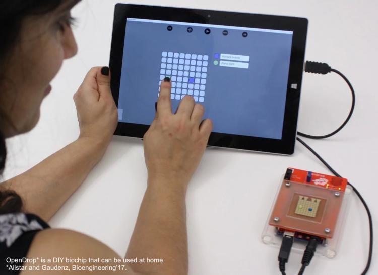 Person using a tablet to control droplets on the OpenDrop biochip