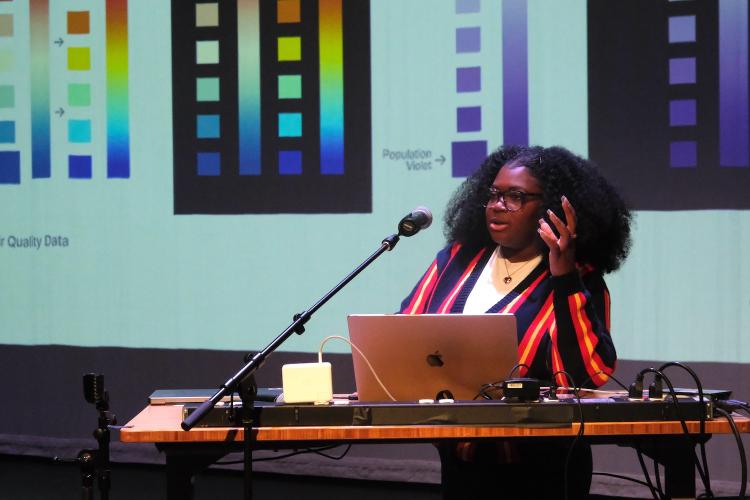 Student presents in front of colorful data visualization