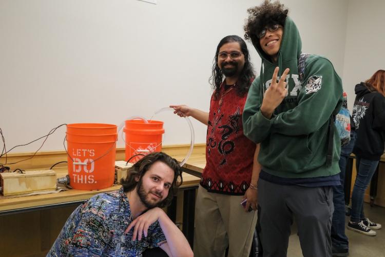 Hacking the Apocalypse project including students demonstrating a water system with plastic buckets