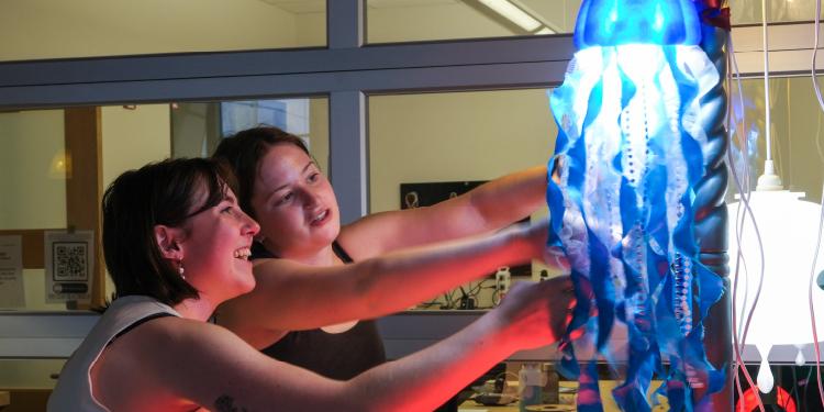 Students working on a light that evokes a jellyfish