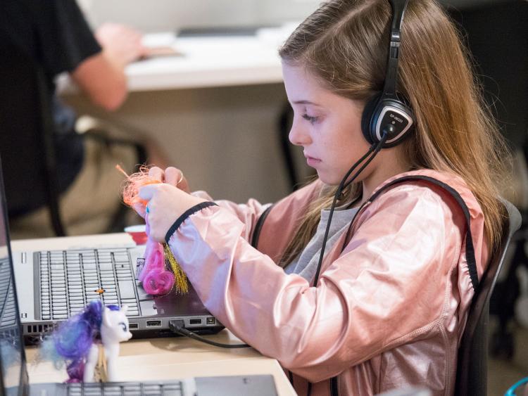 Girl with headphones programs doll