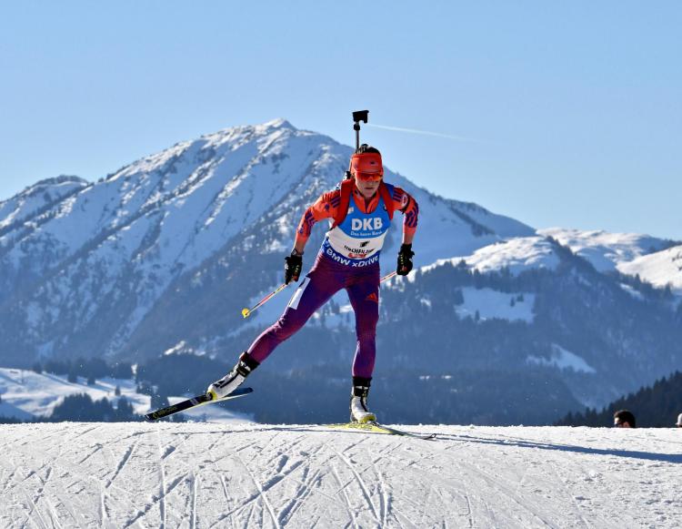 Joanne Reid skiing with a rifle on her back