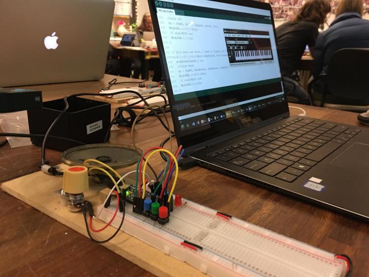 Computer screen showing a piano keyboard with the computer attached to a breadboard.
