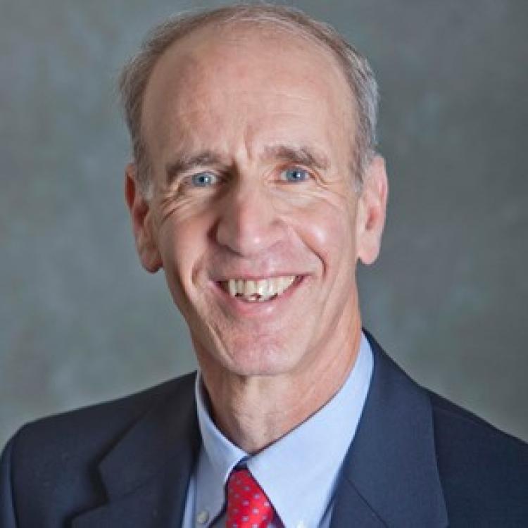Bobby Schabel in a navy blue suit with a blue shirt and red tie