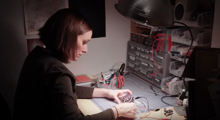 Alicia Gibb assembles hardware at her desk.