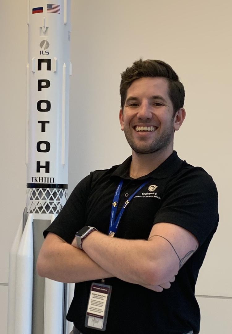 Aidan Rafferty stands by a model of a rocket