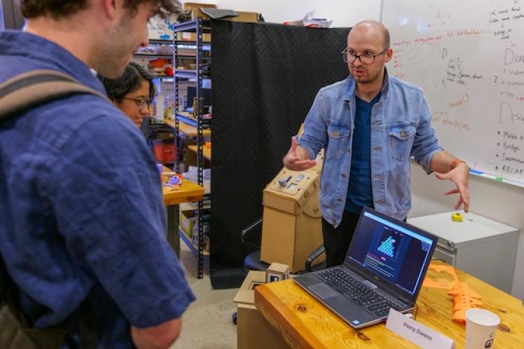 PhD student explains a computer-based project to a guest