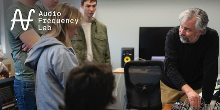 Link to Audio Frequency Lab page with image of professor demonstrating a synthesizer for students