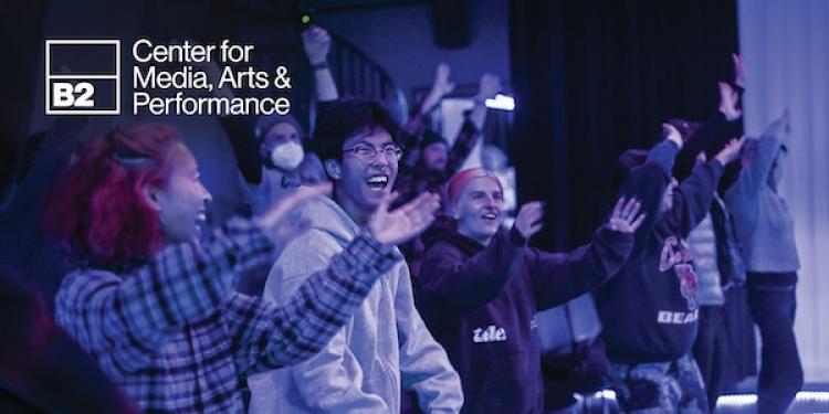 Link to B2 Center page with image of students enjoying a performance in the Black Box