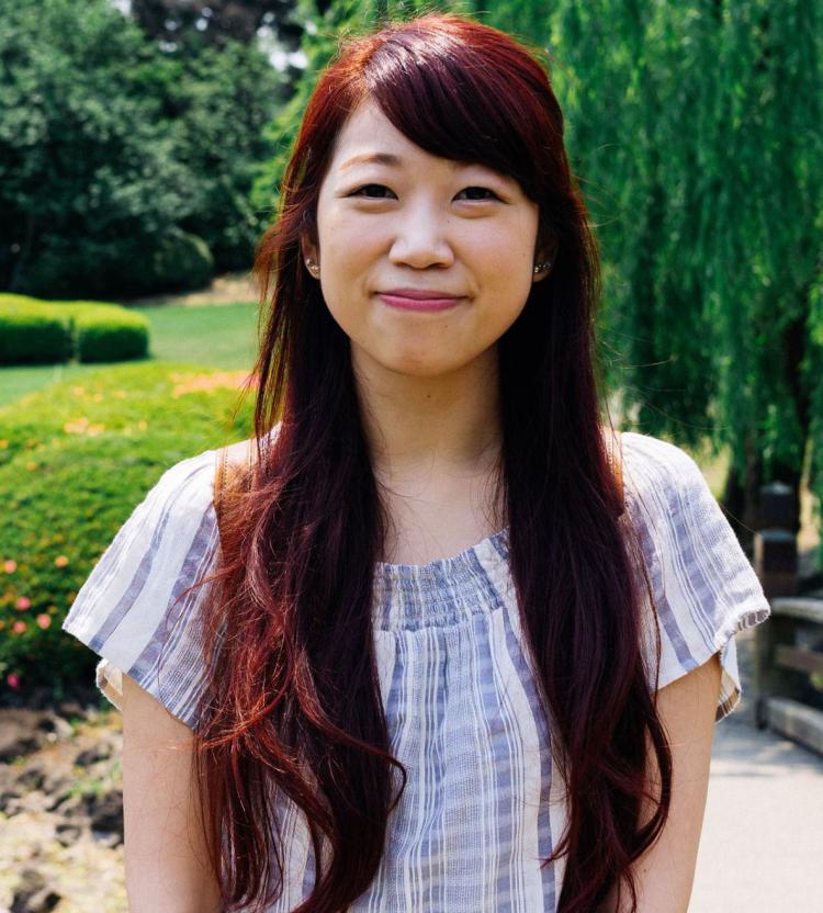 Emily Lin in front of trees and shrubs.