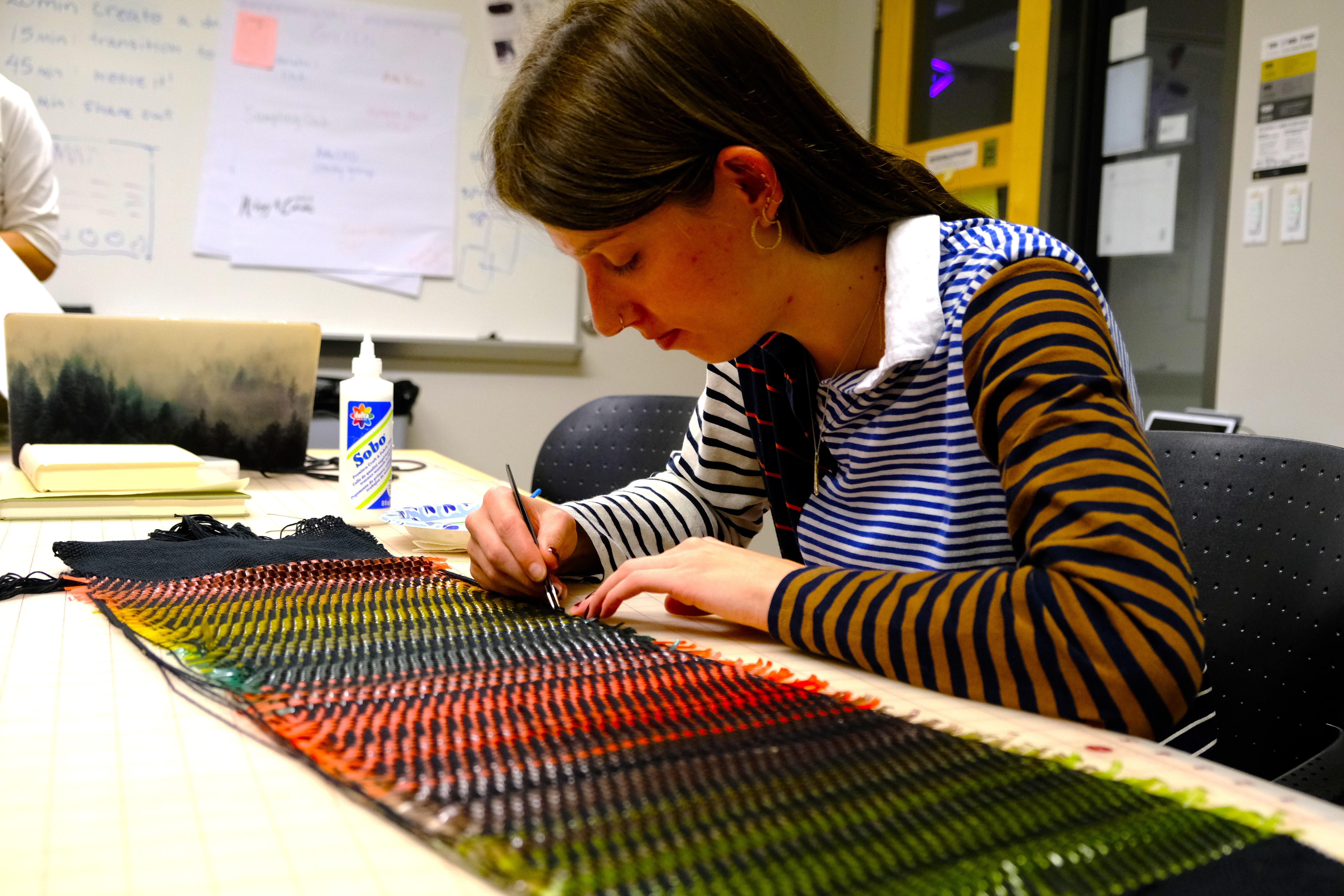 Person working on a colorful tapestry