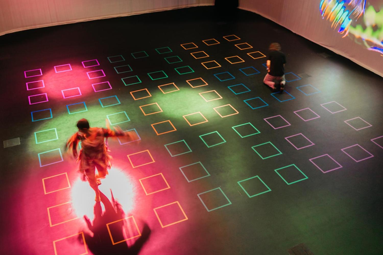 two dancers dancing on a gridded floor