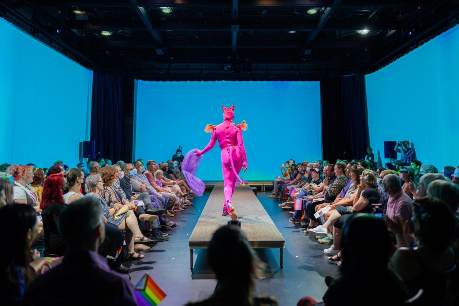 model walking the runway in a pink animal suit with a tail