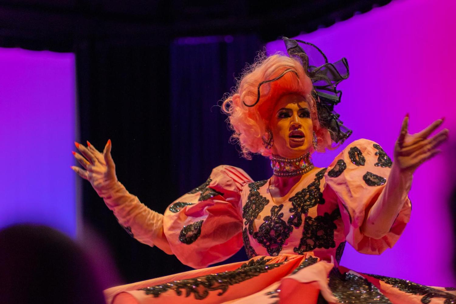 drag queen performing in a pink spinning dress