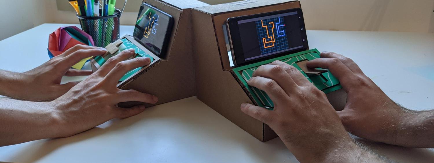 hands playing with tiny arcade games