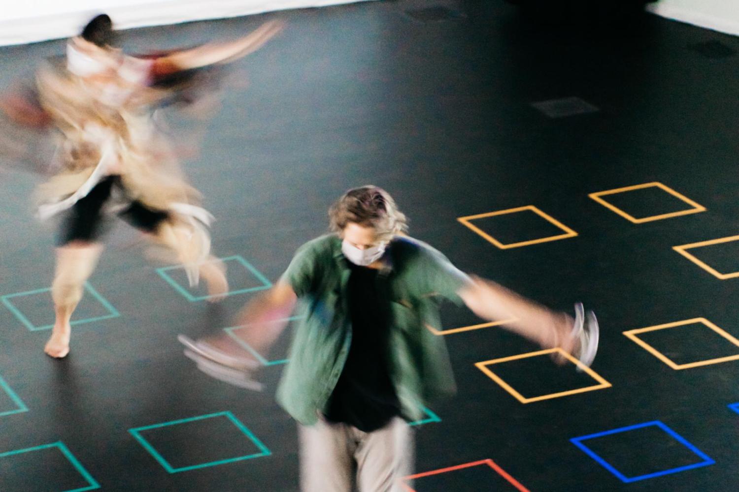 two dancers on a gridded floor dancing