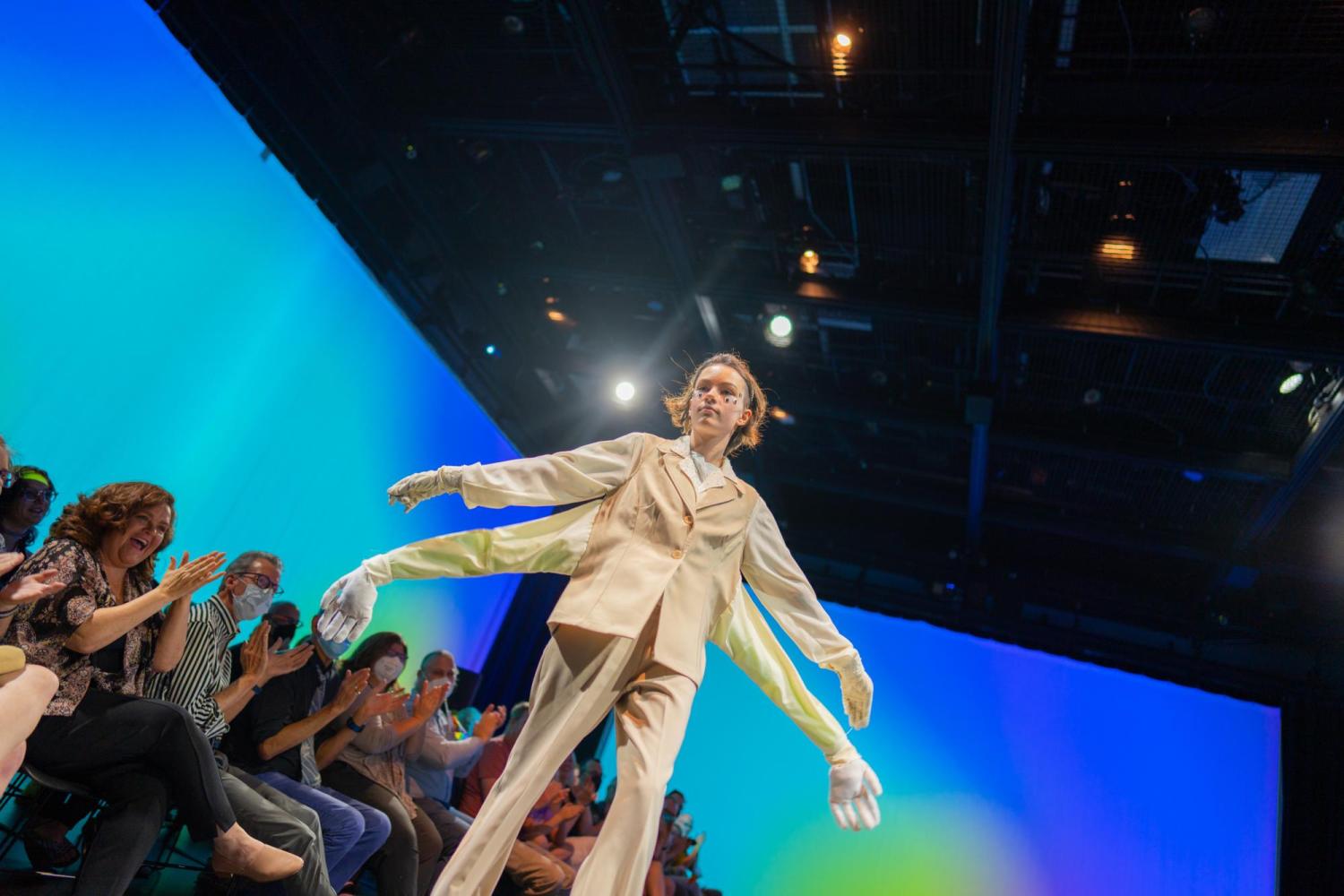 teen model posing in a white suit with four arms