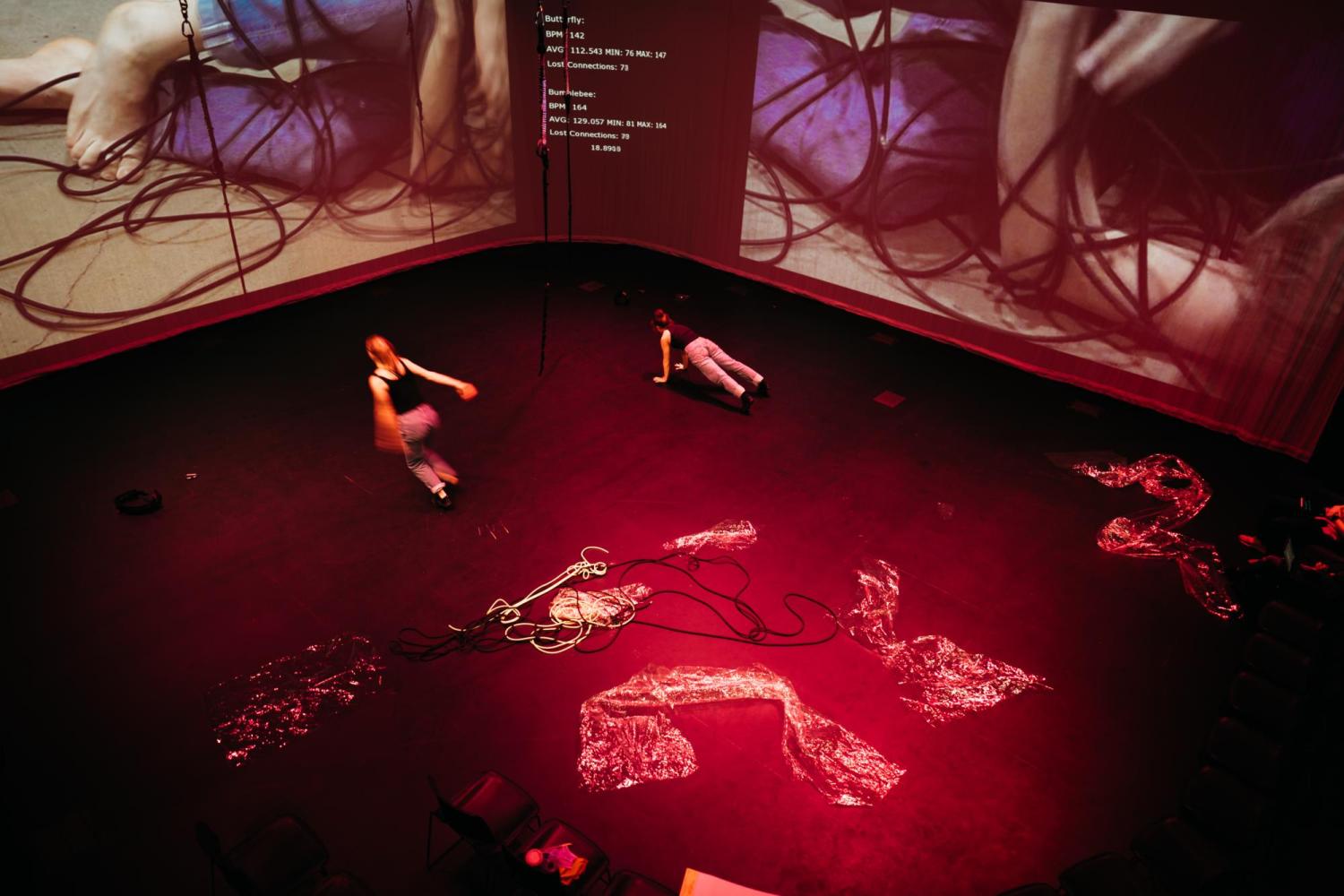 a red lit room with dancers running around