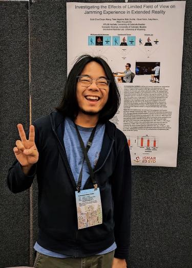 Weng standing with his poster on extended reality research
