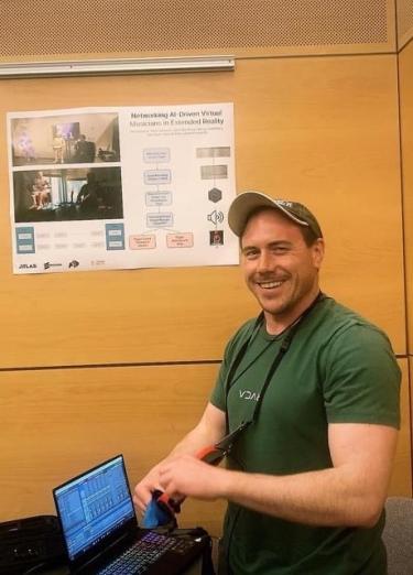 Hopkins standing with his poster on extended reality research