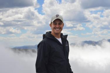 Image of Chris Griffin with clouds and mountain top behind