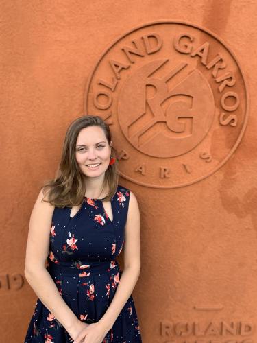 Jessie Hamilton in front of a wall that says Roland Garros Paris.