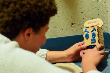 a person playing with a small handmade wood game