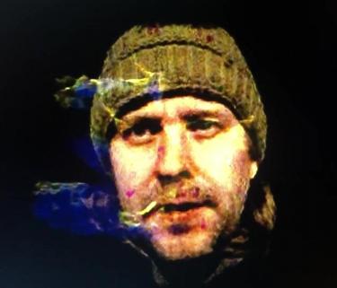 headshot of brad gallagher wearing a hat and surrounded by smoke