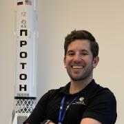 Aidan Rafferty stands by a  model of a rocket