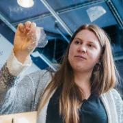 Fiona Bell peels a bioplastic sample off of  glass