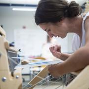 Laura Devendorf weaves on a loom.