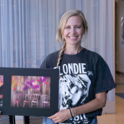 Larissa Schwartz holds AI-generated art created by students