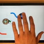 Demonstration of haptic video with small circular robots following a path created on screen by user.