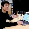 Ryo Suzuki demonstrates AI textbook software on a laptop in his lab