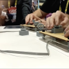 Hands playing HOT SWAP, a game where the controllers are reconfigurable.