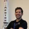 Aidan Rafferty stands by a model of a rocket